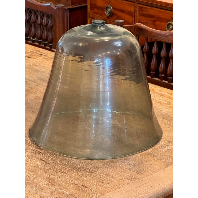 A cloche with a bell-shaped form, shown without a finial; the top appears broken where a knob would have been. The body...
