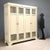 Lacquered fir pantry cabinet. Front with four tripartite doors, central wooden panel, upper and lower with mesh. Italy,...