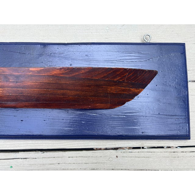 An American half hull made of typical stacked pine construction and mounted on a dark blue backboard, probably dating from...