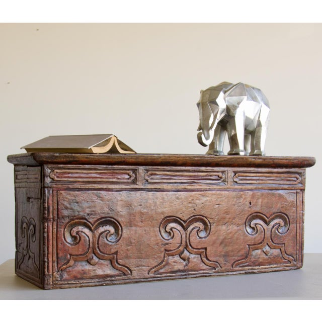 Small Tibetan low table in softwood, carved on three sides with a repeating scrolling motif set within recessed panels,...