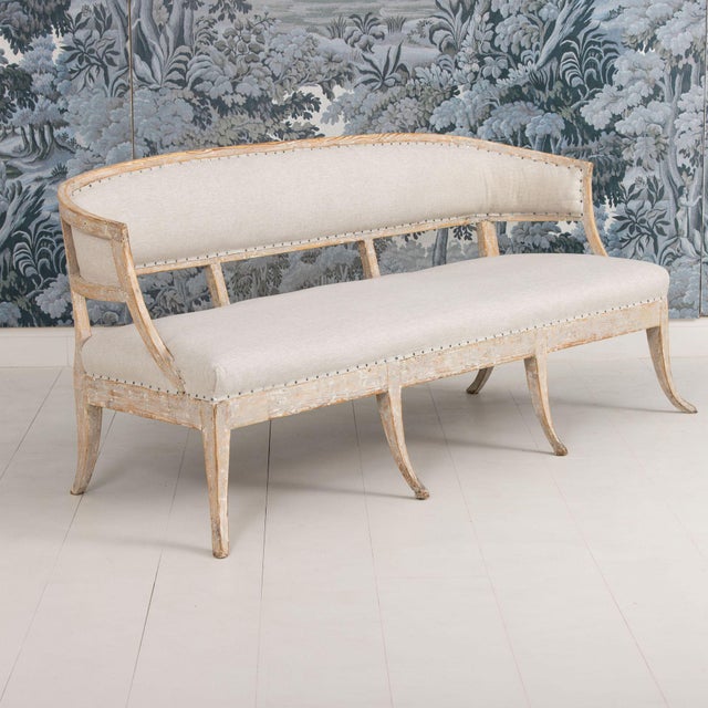 A beautiful 19th c. Swedish sofa bench from the Gustavian period, newly upholstered in linen fabric with nail head trim....