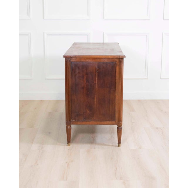 A refined French Louis XVI style chest of drawers, expertly crafted in solid walnut and defined by its clean neoclassical...