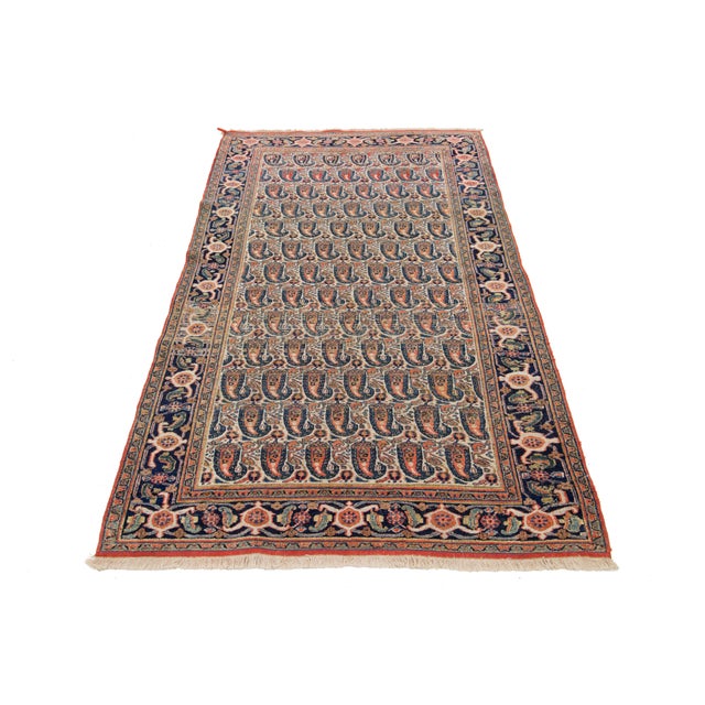 This is a handmade Persian Malayer rug from the 20th century. It features a beige field with orange and blue accents...