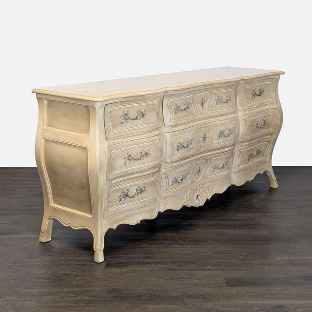 This Henredon dresser features a classic French Provincial design with elegant curved lines and ornate drawer handles. It...