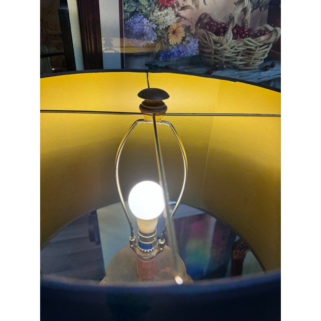 A striking vintage carved wood table lamp featuring a classical urn-form silhouette with richly detailed scrolling...