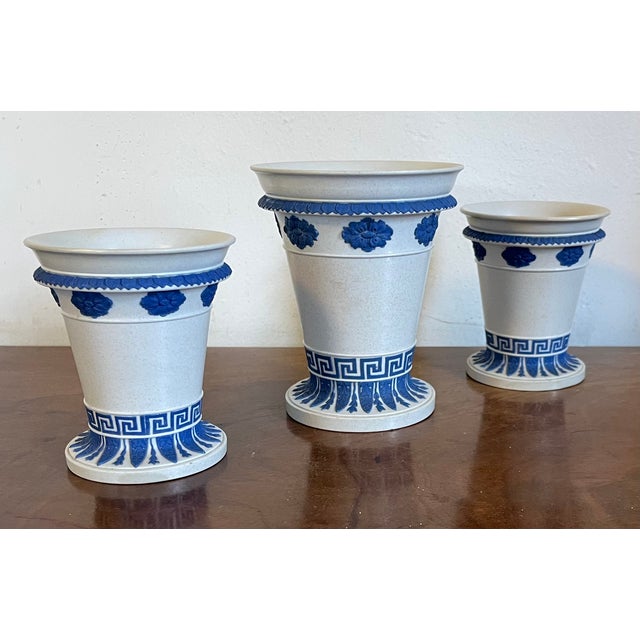 Mantel garniture of three early 19th c. Wedgwood jasperware vases with white ground and blue relief decoration in the...