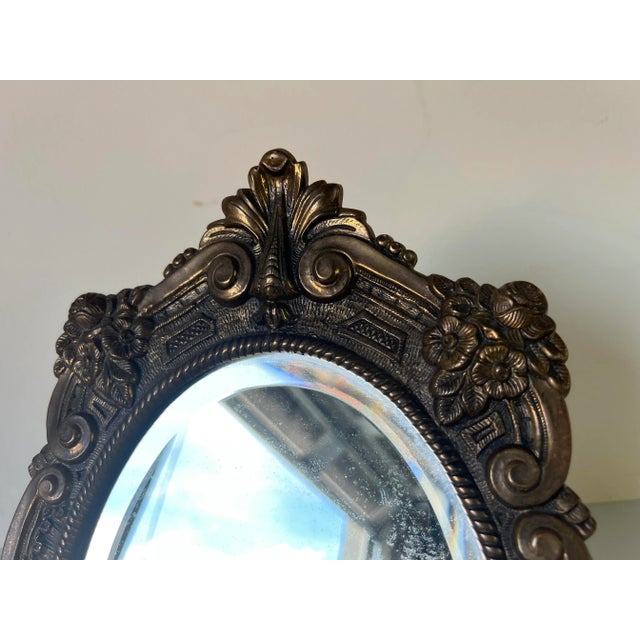 Gorgeous Vintage solid brass table top vanity mirror. The piece features a very ornate floral design with beveled oval...