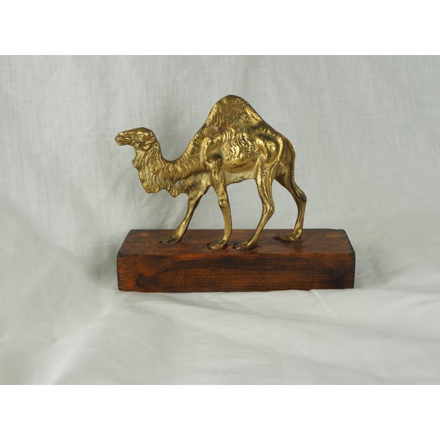 Late 20th Century Moroccan Brass Camel on Wooden Display Stand This figure with beautiful patina and fine details is a...
