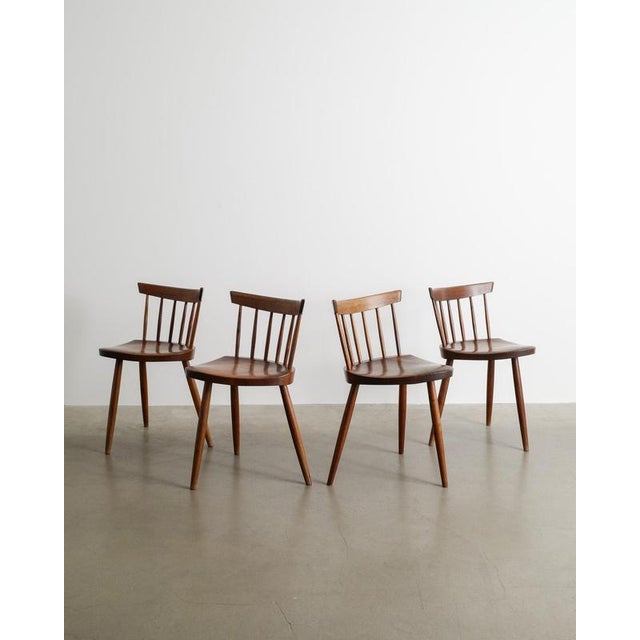 A rare set of four mid century wooden dining chairs in dark stained american walnut by george & mira nakashima produced as...