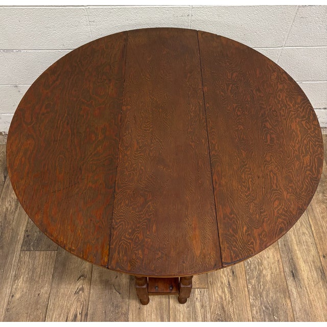 This is a rare and gorgeous antique tiger oak drop leaf gateleg round occasional table, side table, or center table....