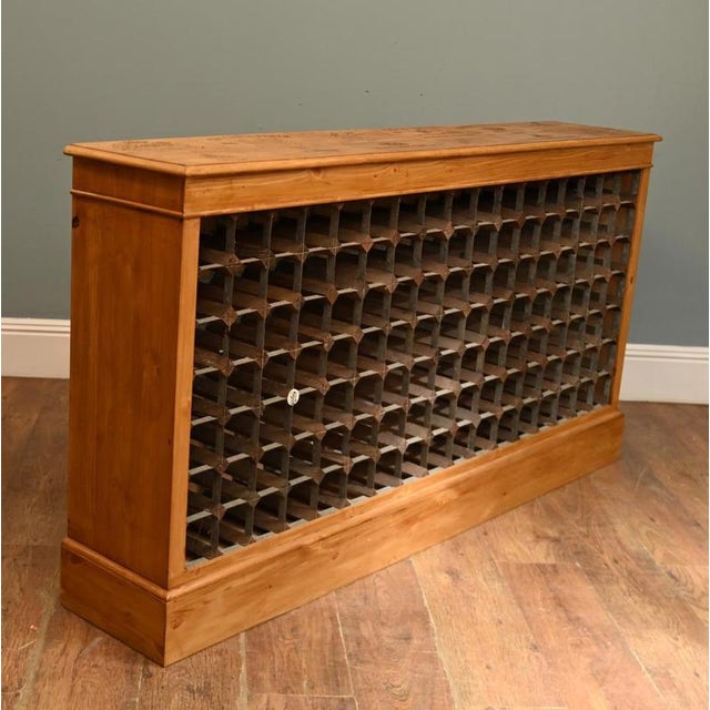 A substantial and highly decorative pine wine rack, featuring a bespoke top crafted from authentic vintage French wine...