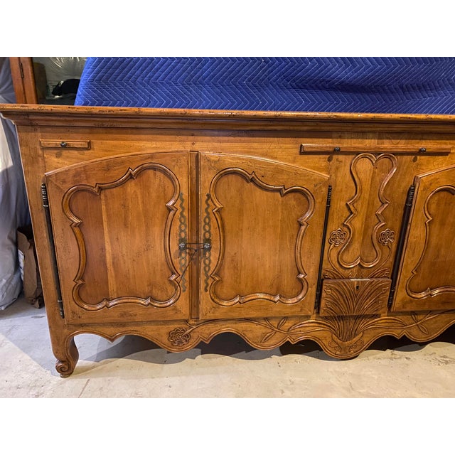 Grand scale, intricately carved, with a fine finish. Top features a planked design. There are 3 pull-out shelves on the...