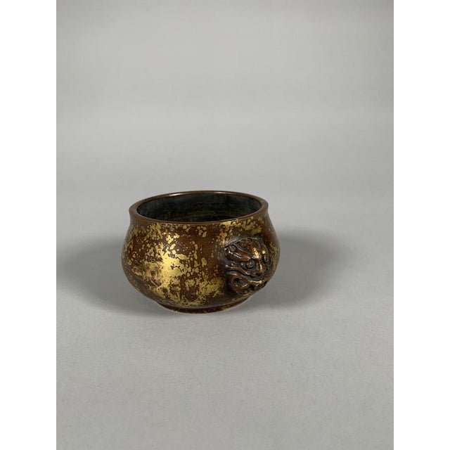 A patinated bronze incense burner from the Qianlong period (1735-1796), 18th century. It features a gold-splash technique....