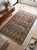 This large handwoven Afghan Ghalmori Maimana kilim has a deep brown and charcoal gray base with muted blue, cream, taupe,...