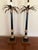 Pair of neoclassic candlestick lamps with stylized brass palm tree tops with a bud candleholder. Bodies are black and gold...