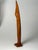 Hand-carved sculpture in solid teak depicting a stylized female figure leaning into a boat. One hand supports the boat...
