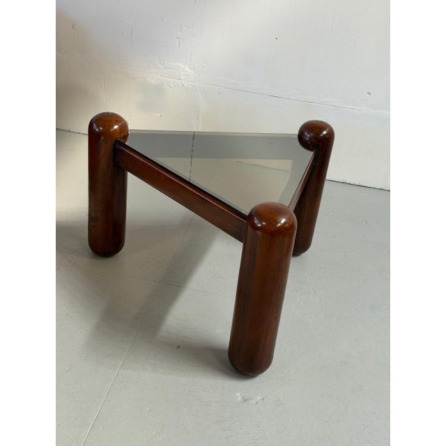 A rare and sculptural side table by Gruppo DAM, built on three robust solid mahogany posts arranged in a triangular base...