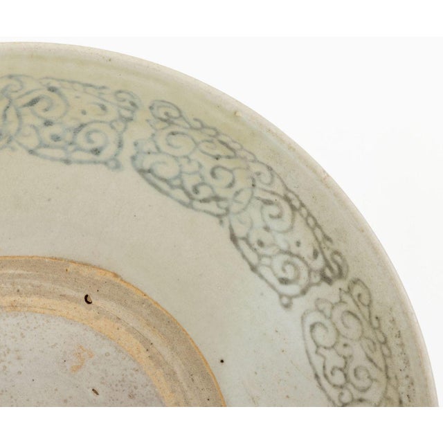 Chinese Blue and White Ceramic Bowl, with cobalt blue scroll form motif to the interior rim. 3" H x 12.25" Diameter....