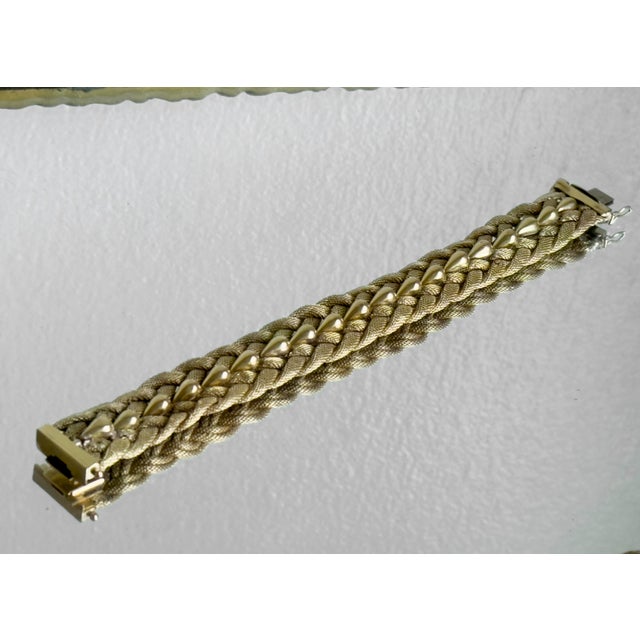 Vintage 1960s Italian bracelet by UnoAErre, crafted in 18k solid yellow gold. Wide braided Milanese-style mesh...