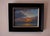 This oil on panel painting captures a serene sunset over the ocean, where vibrant oranges blend seamlessly with deep blues...