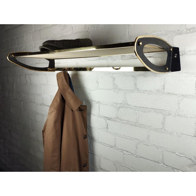 1950s wall-mounted coat rack with 5 hooks and a metal mesh hat shelf.