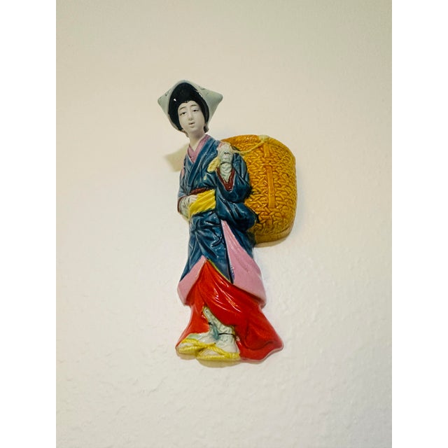 This vintage hand-painted ceramic wall pocket features classic lines and craftsmanship representative of its era. It...