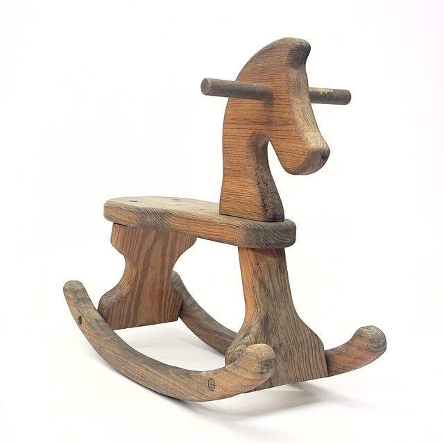This beautifully aged wooden rocking horse showcases classic folk art craftsmanship. With its rustic charm and sturdy...