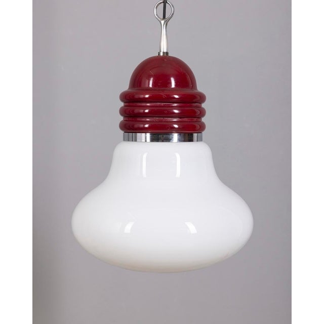 Small red metal pendant lamp with a large white glass shade, adjustable height. Designed by Piero Brombin for Artemide,...
