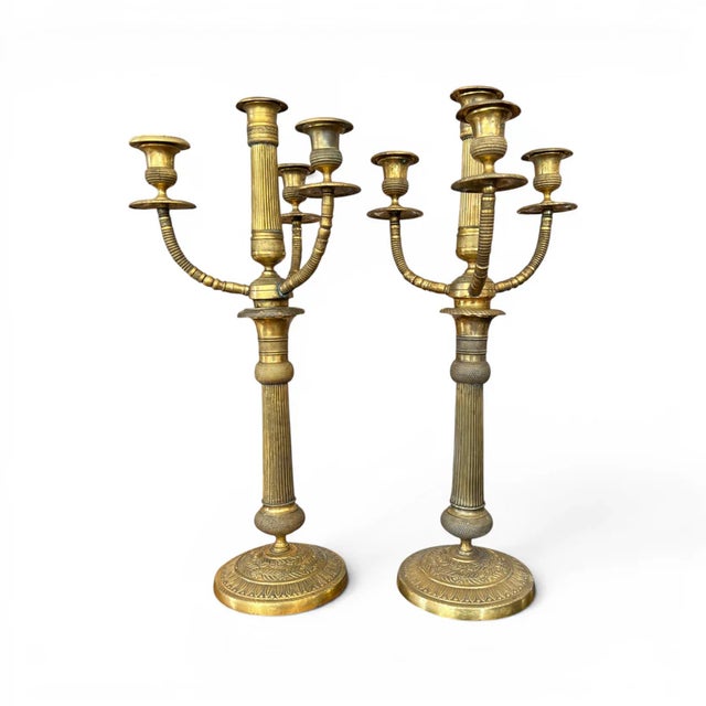 An elegant pair of early 20th-century brass candelabras featuring classic proportions and a beautifully aged patina....