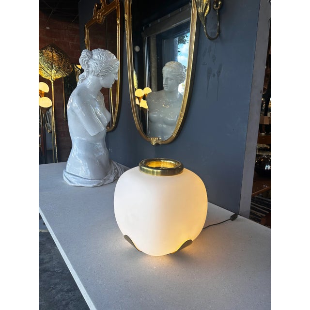 Illuminate your space with the timeless elegance of this Mid-Century Italian Opaline and Brass Table Lamp from the 1970s....