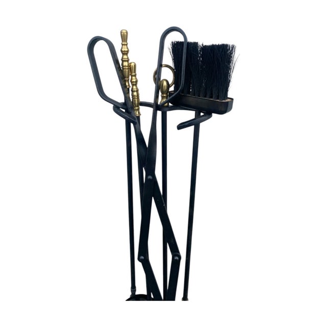 This beautiful mid-century vintage fireplace tool set features a sleek black and brass design, adding a touch of elegance...