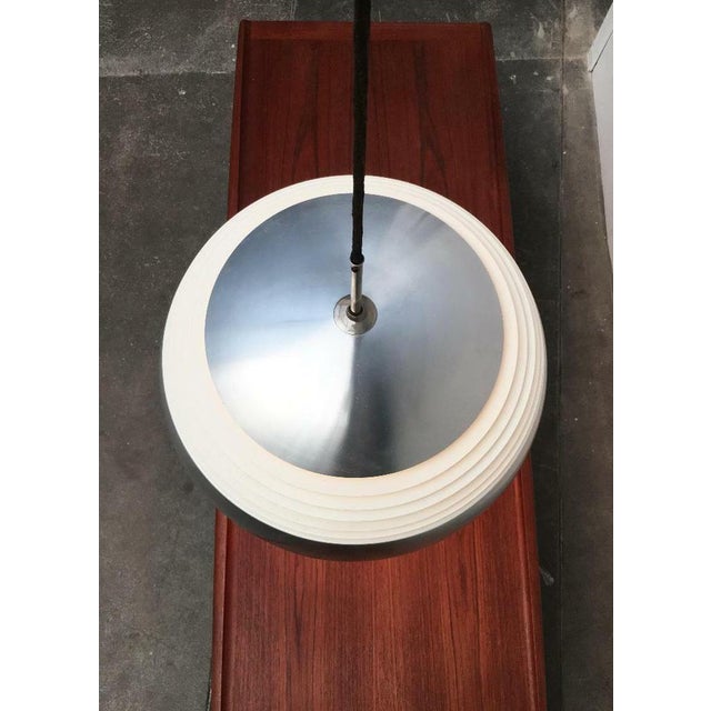 Rare mid-century louvre pendant light from Doria. The lamp has a classic dome shape. The centre section is broken up into...