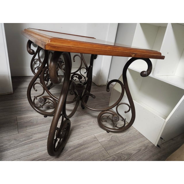 This Ethan Allen coffee table and end tables features a wrought iron accent table styled with a polished wooden top and an...