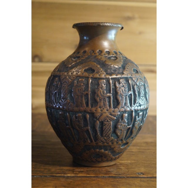A vintage Persian vase which is done in copper relief and features religious figures on all sides. In very good vintage...