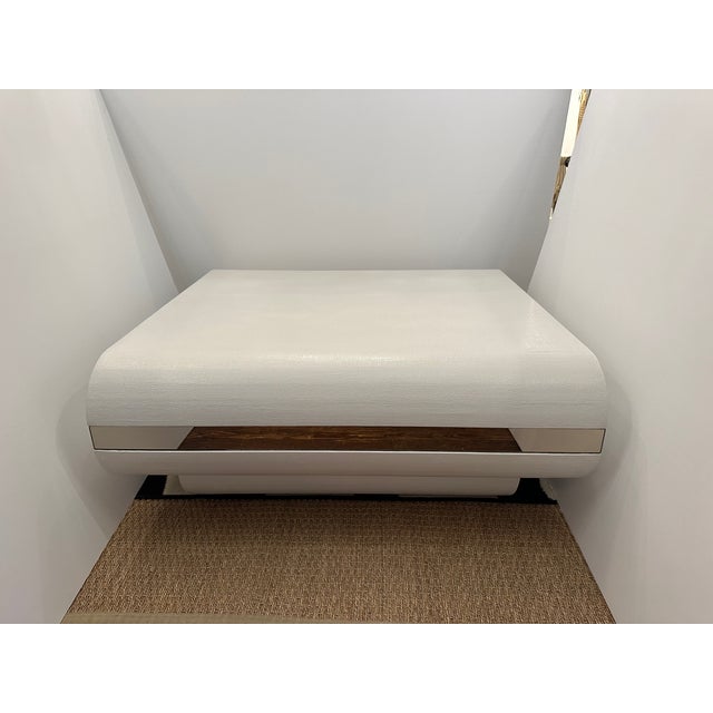 Glamorous modern square linen or grasscloth textured wrapped coffee table newly refreshed in white paint, having a sleek...