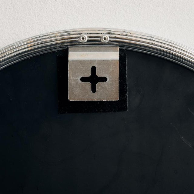 Curved mirror with a ribbed metal frame from the 1970s. with some surface scratches, stains and wear on the metal and...