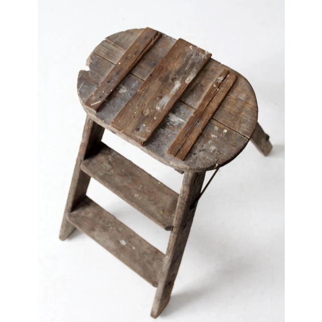 This vintage folding step ladder is a charming piece with a rustic patina. Its weathered wood and folk repairs tell a...