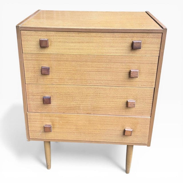 A stylish mid-century compact teak chest of drawers, offering clean lines and practical storage in a classic 1960s design....