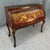This early 1900s antique rolltop desk features an elaborately inlaid fall front with a detailed village scene crafted from...