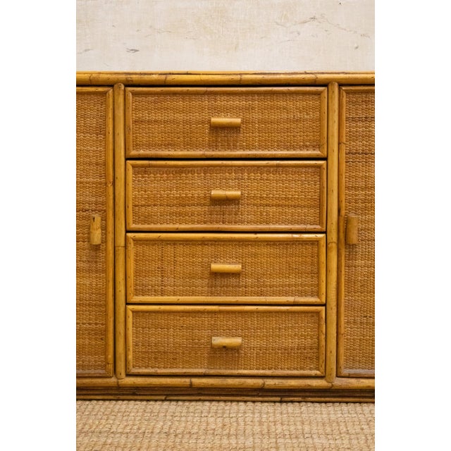 1970s sideboard featuring a bamboo structure with surfaces covered in woven rush. Configured with two side doors and four...