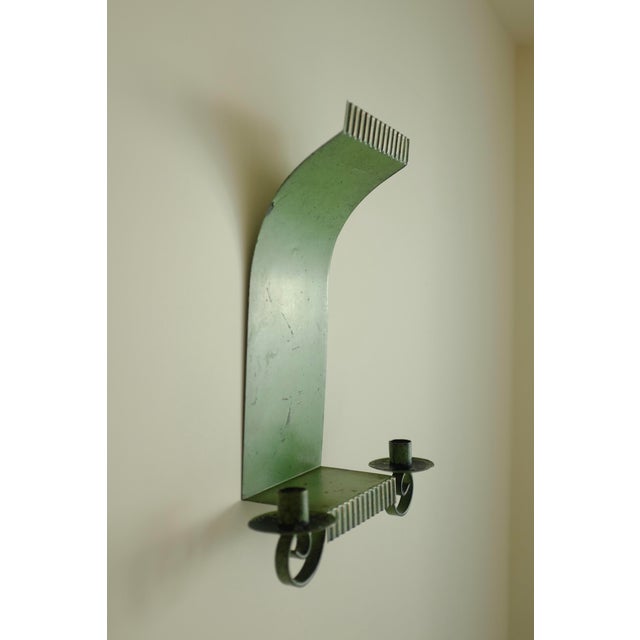Swedish Grace Wall Candle holder in a green painted metal with golden shades at the edges. Holds two candles with vertical...