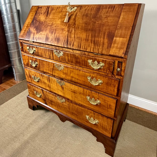 A nicely proportioned New England Chippendale tiger maple slant-front desk dating to the second half of the 18th century....