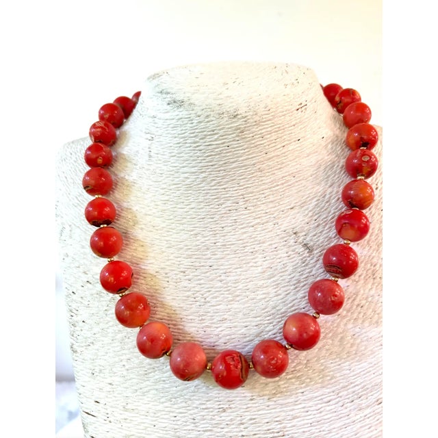 Gorgeous coral beaded necklace with 13 mm beads and gold tone spacers and clasp designed by Matthew Izzo.
