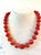 Gorgeous coral beaded necklace with 13 mm beads and gold tone spacers and clasp designed by Matthew Izzo.