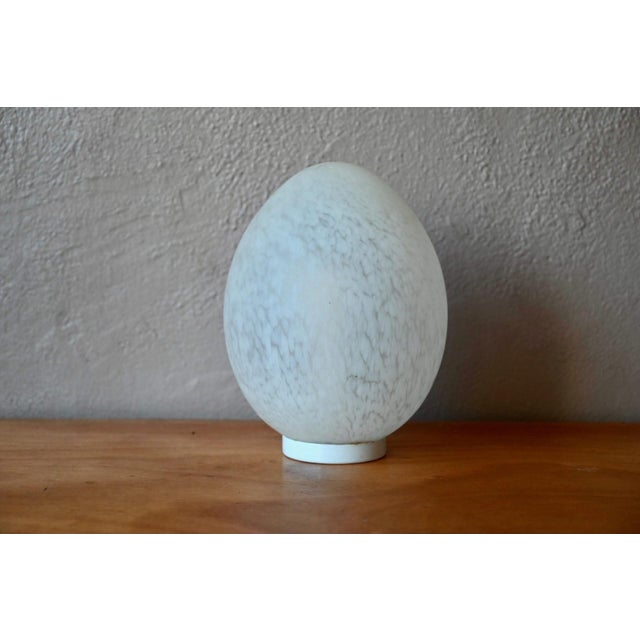 Original, soft, and elegant, this table lamp is crafted from Vianne glass. The egg-shaped shade is made of opalescent...