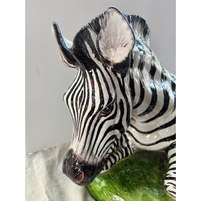 A monumental glazed terracotta zebra resting in the grass, made in Italy, probably in the 60's. Great expression in the...