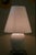 Original table lamp designed by Tommaso Barbi and crafted from a single piece of white glazed ceramic in the shape of a...