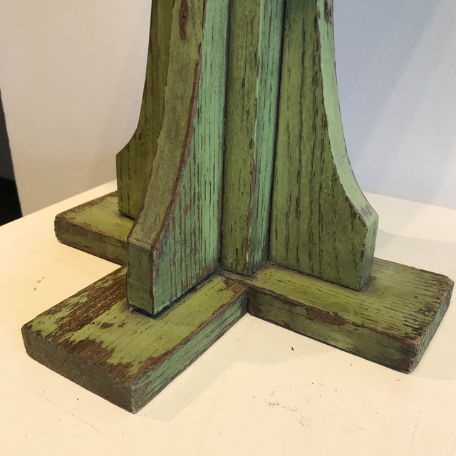 Wooden square top small pedestal table in vintage avocado green.