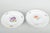 Four porcelain plates, hand-painted with multicoloured floral decorations. Classic scalloped rim with relief and delicate...