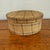 Antique rustic round band box with a fitted lid, covered in a tan plaid fabric crossed with black and brown stripes. This...